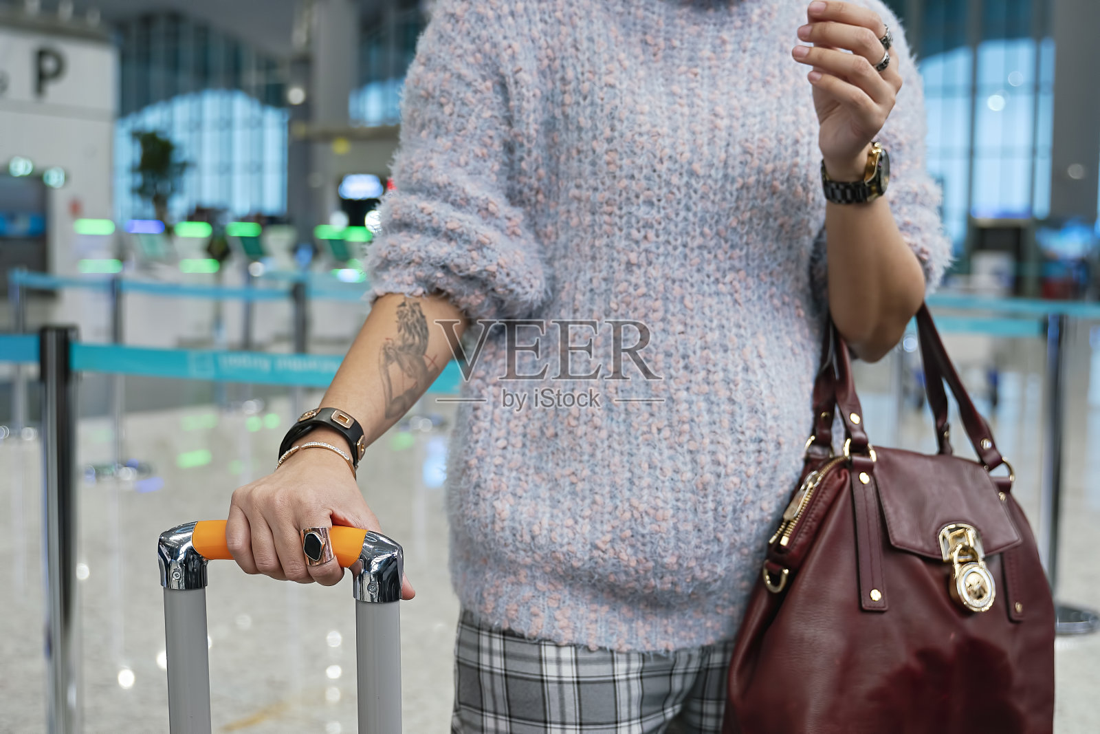 一个女人拿着钱包和行李在机场候机照片摄影图片