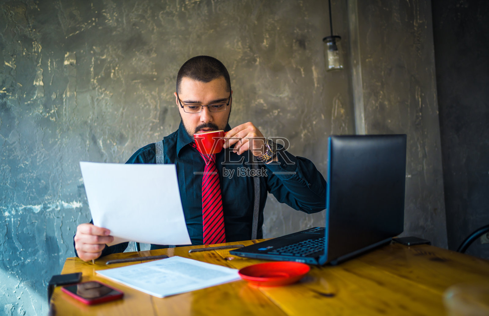 在咖啡馆阅读文件的年轻商人照片摄影图片