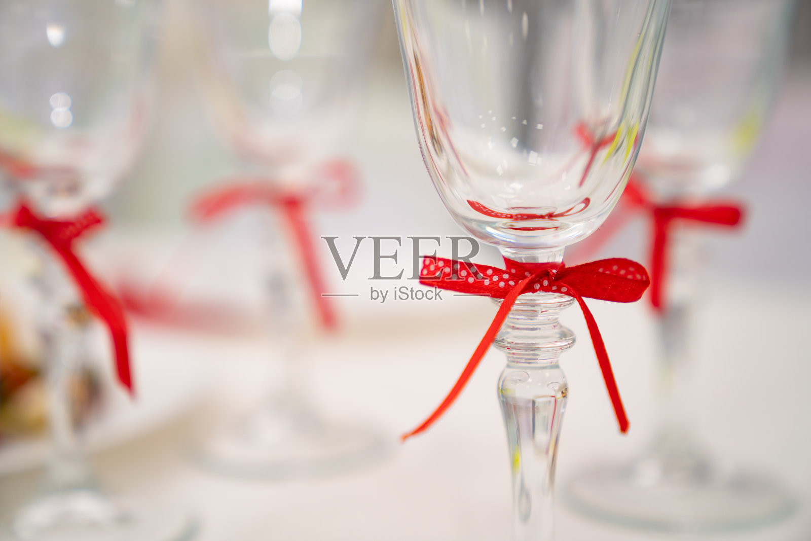 用红丝带系着的玻璃腿。照片摄影图片