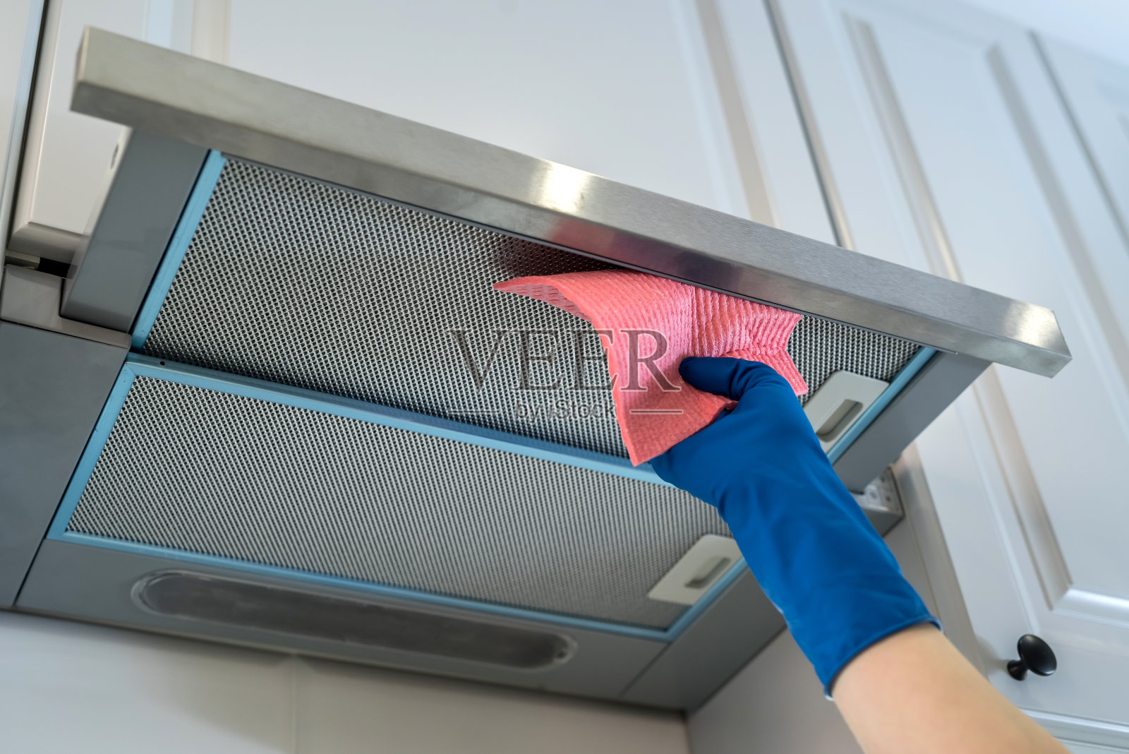 女人戴橡胶手套清洁抽油烟机照片摄影图片