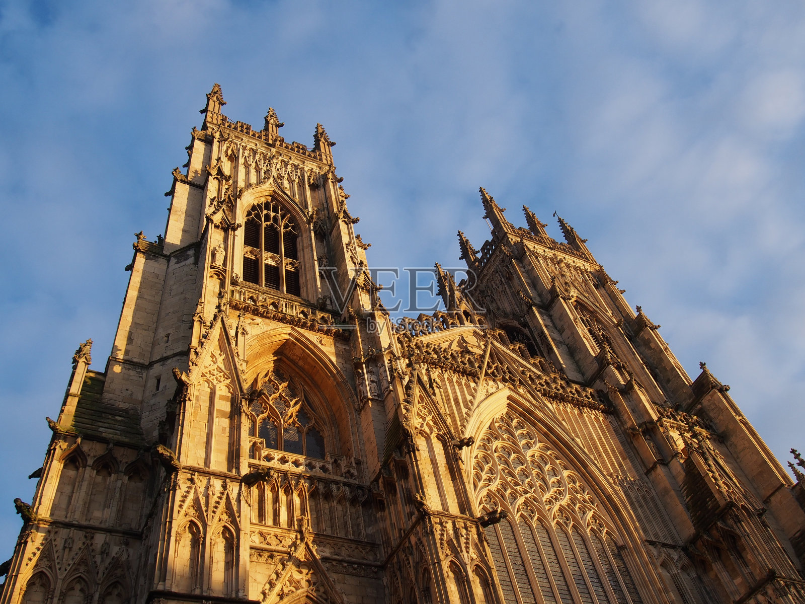 在阳光下的蓝色多云的天空，在约克敏斯特入口处的塔的正面视图照片摄影图片