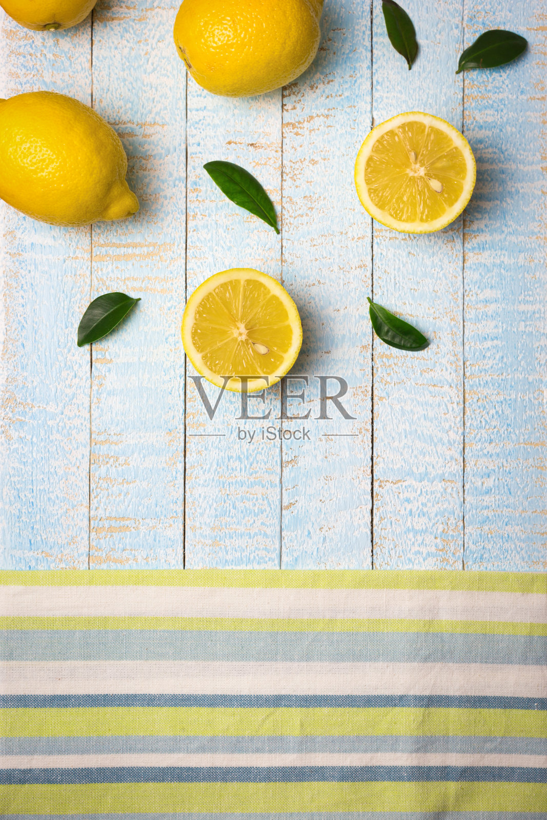 淡蓝色木质背景上的成熟柠檬照片摄影图片