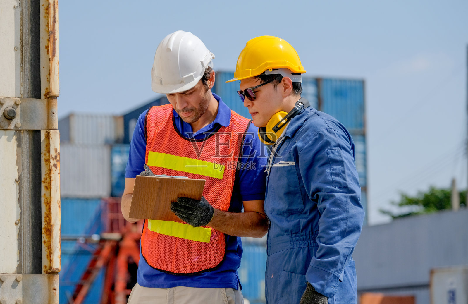 技术员和工程师在货运集装箱运输区合作检查质量和产品照片摄影图片