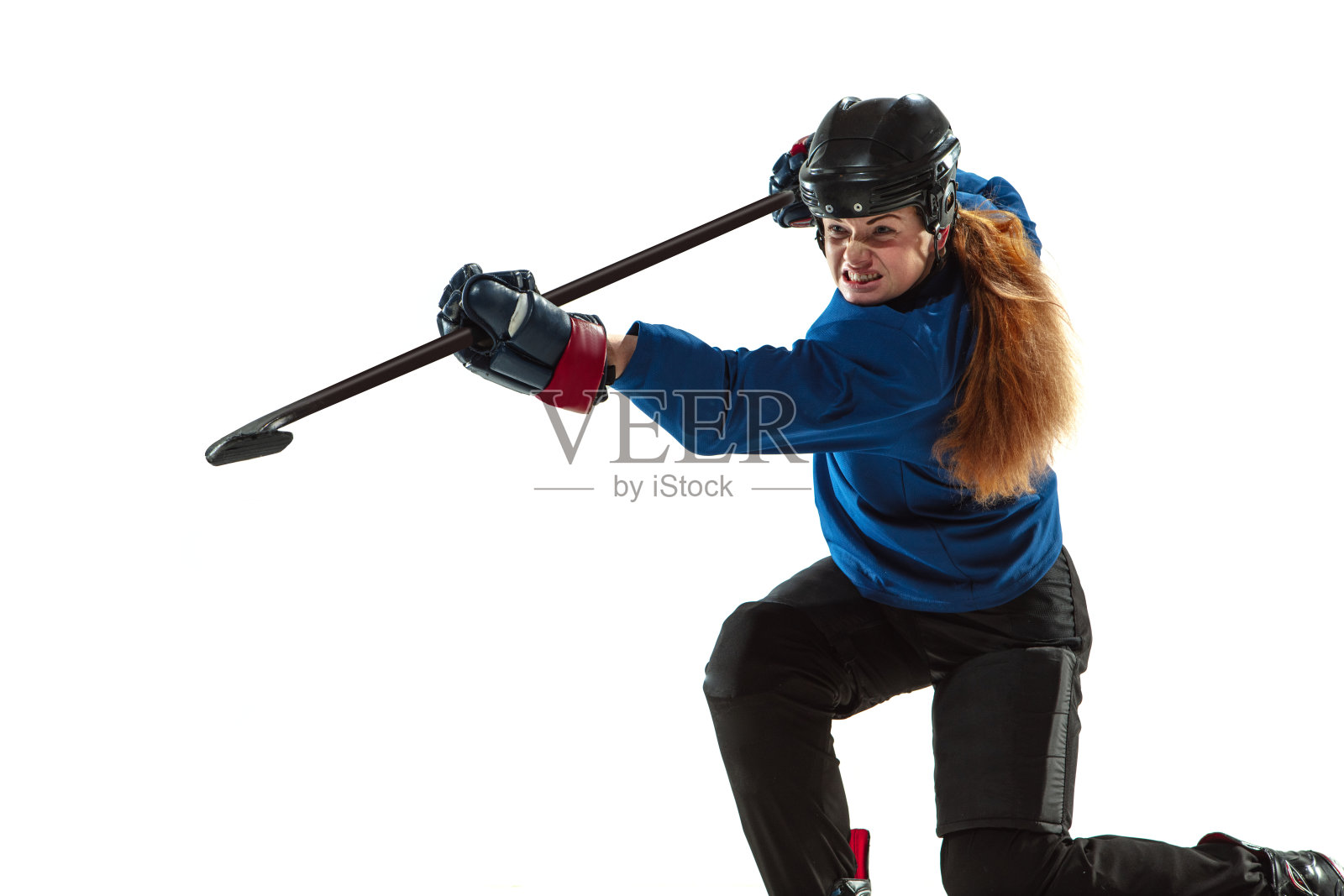 年轻女曲棍球运动员手持球杆站在冰场上，白色背景照片摄影图片