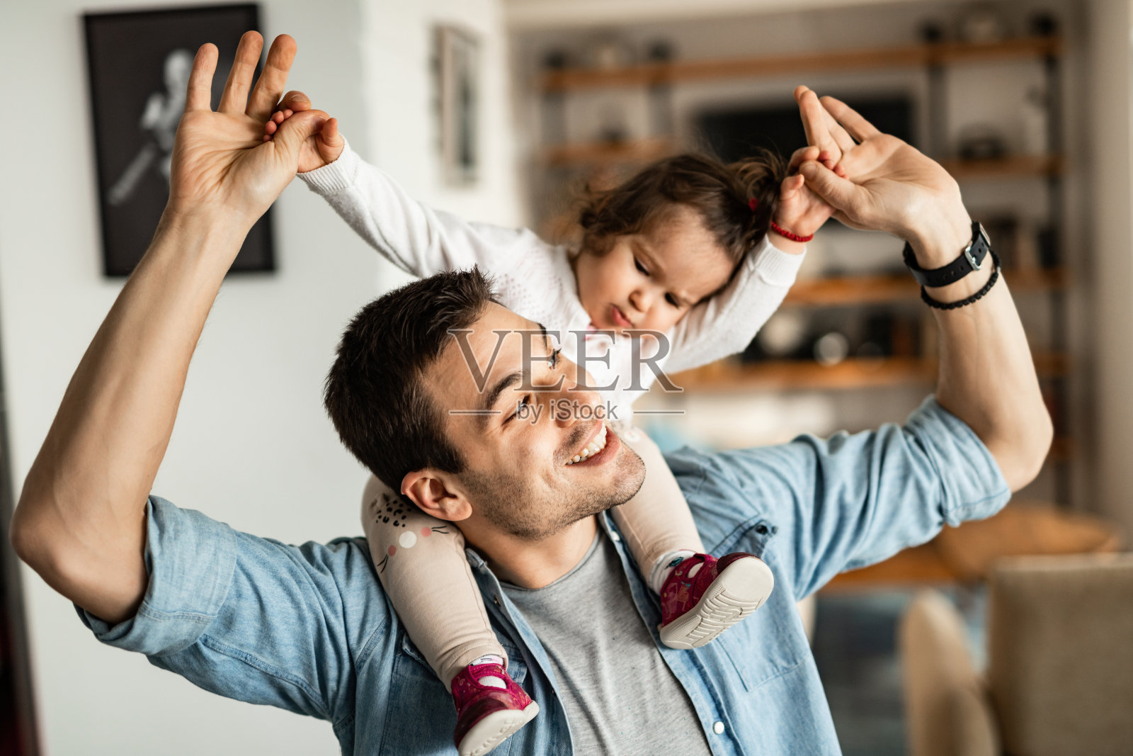 父亲在家开心地把小女儿扛在肩上照片摄影图片