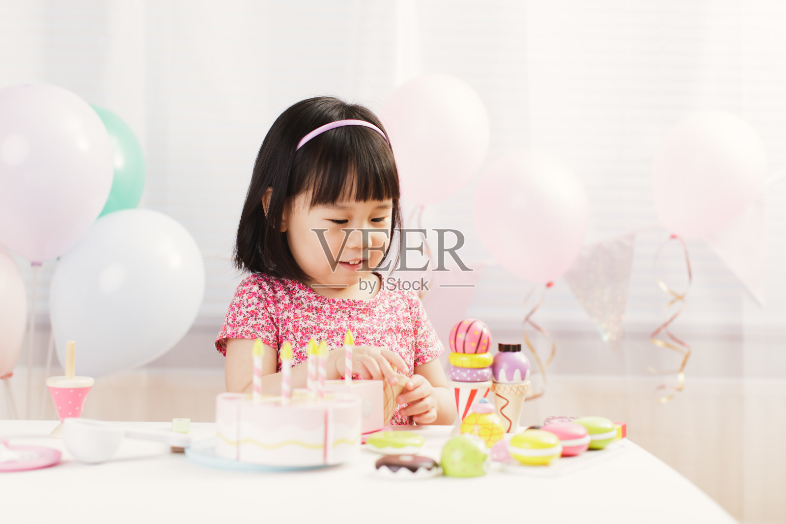 蹒跚学步的小女孩在白色背景下在家扮演准备食物的角色照片摄影图片