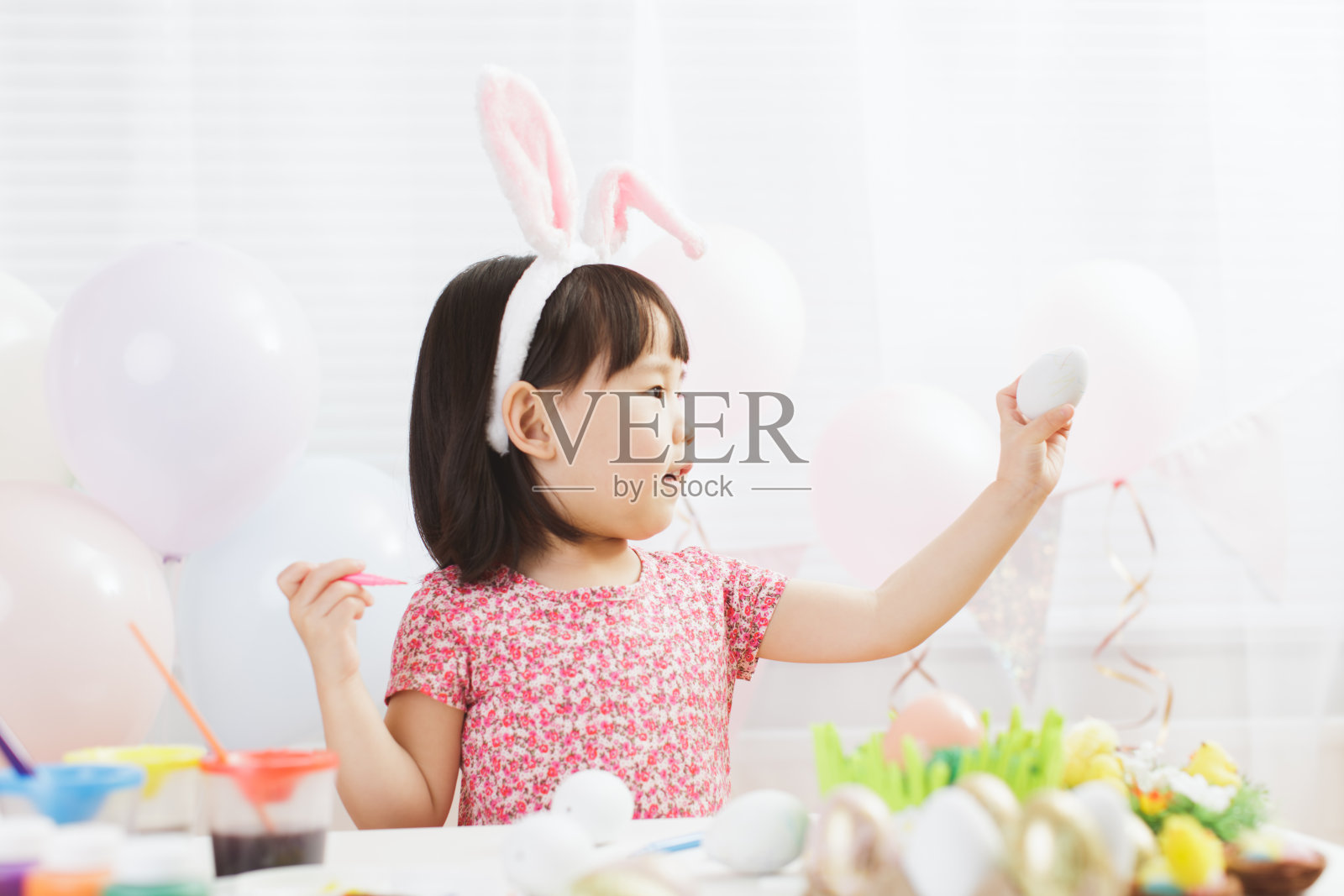 幼儿女孩在家玩复活节彩蛋，白色窗户背景照片摄影图片