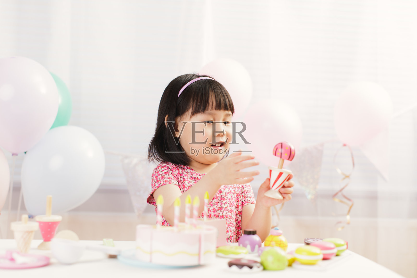 蹒跚学步的小女孩在白色背景下在家扮演准备食物的角色照片摄影图片