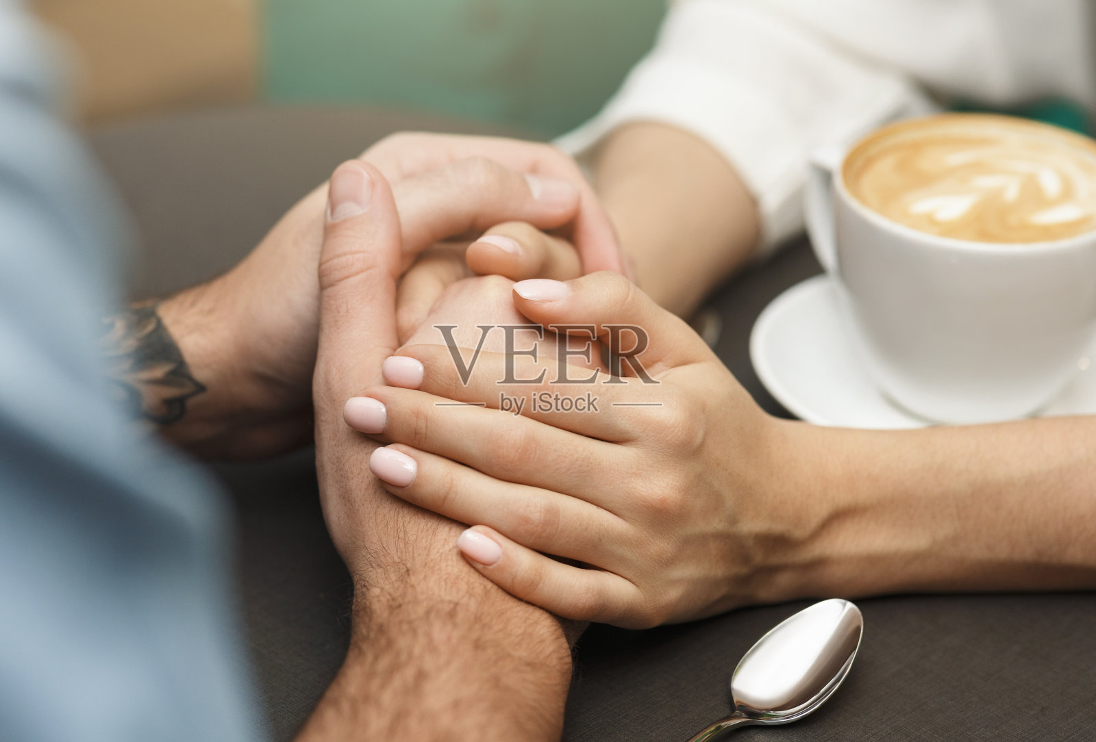 男性和女性在咖啡桌上牵手的特写照片摄影图片