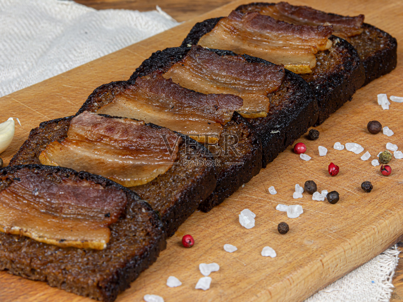 熏肉黑面包吐司，背景是大蒜和盐照片摄影图片