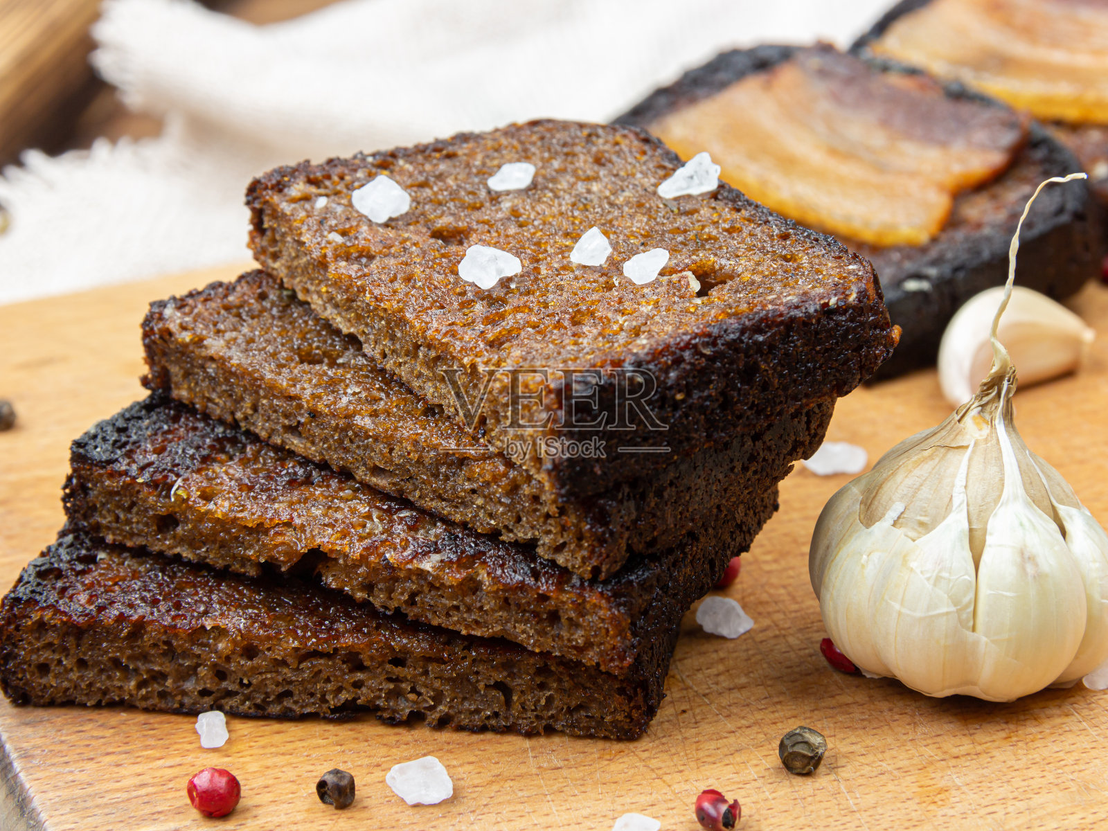 前景的灰色盘子上放着三个面包丁和一个碎了的面包丁。照片摄影图片