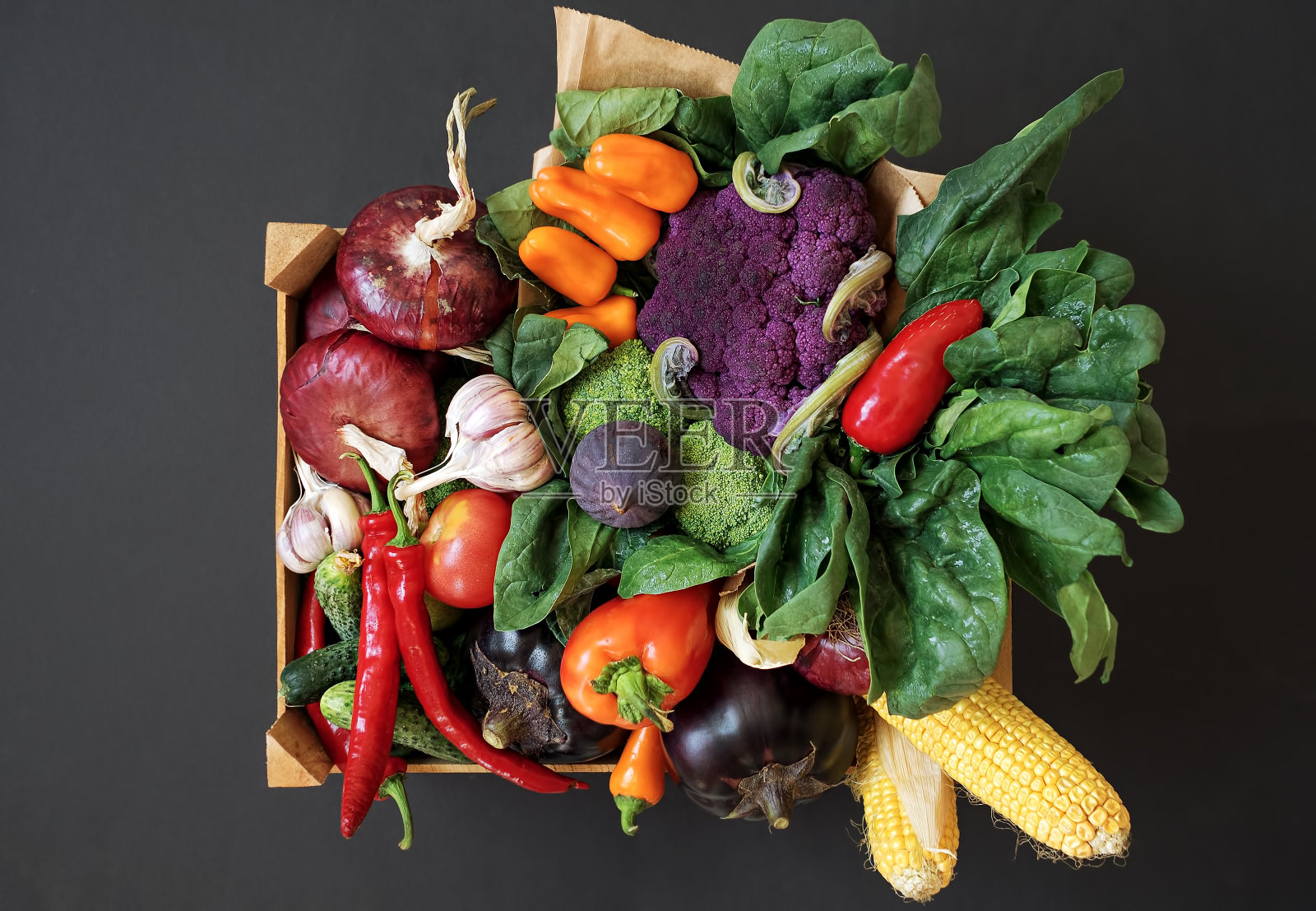 在黑色背景上的木盒子里的新鲜蔬菜。收割。前视图。照片摄影图片