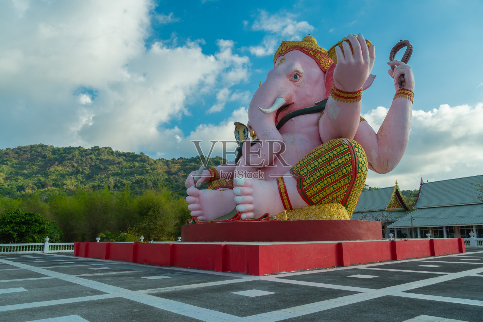 蓝色天空下的粉色象头神雕像照片摄影图片
