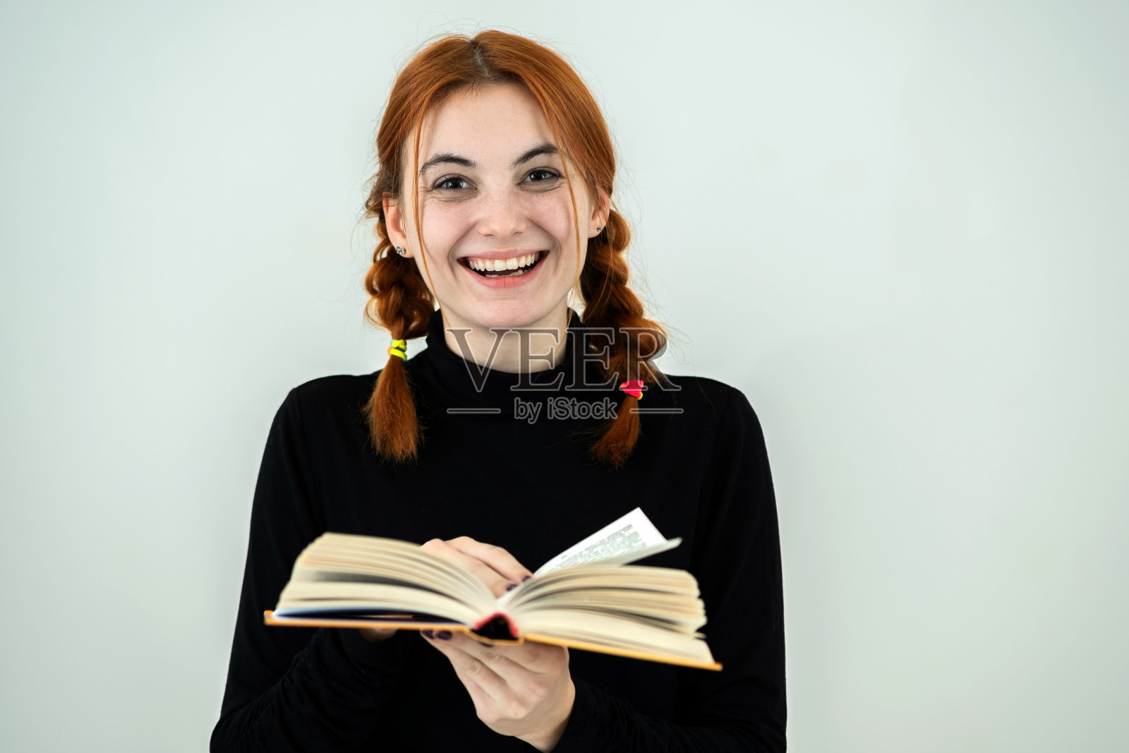 手捧书本的年轻女学生照片摄影图片