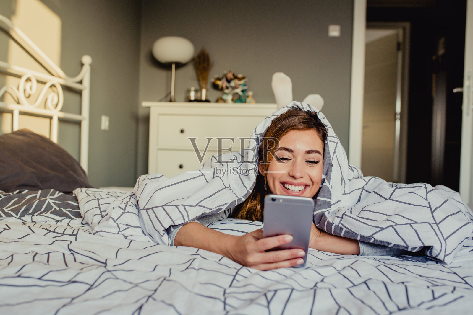 在床上使用智能手机照片摄影图片