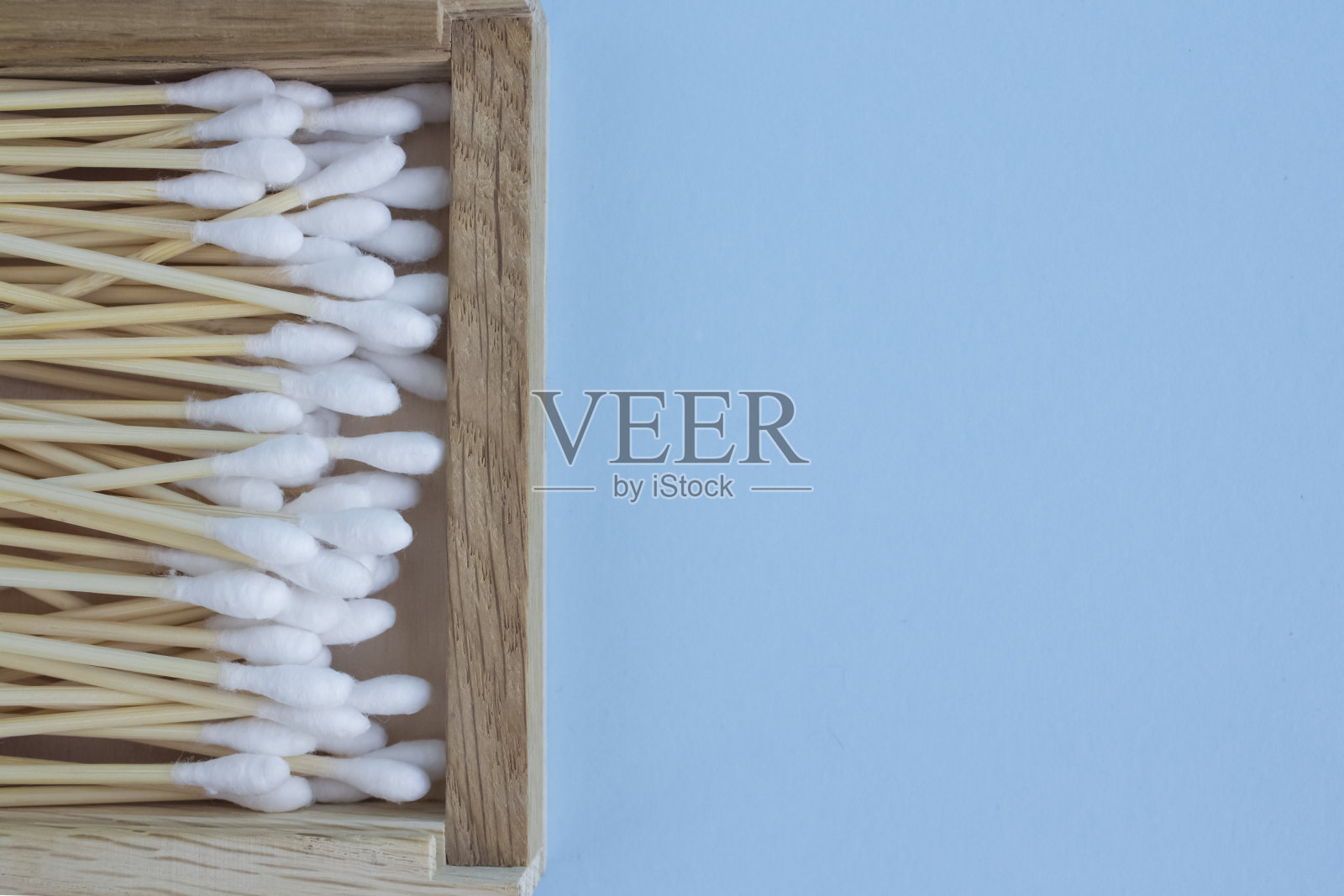 特写竹棉签或棍棒在木盒子上的蓝色背景。复制空间，零浪费理念，环保照片摄影图片