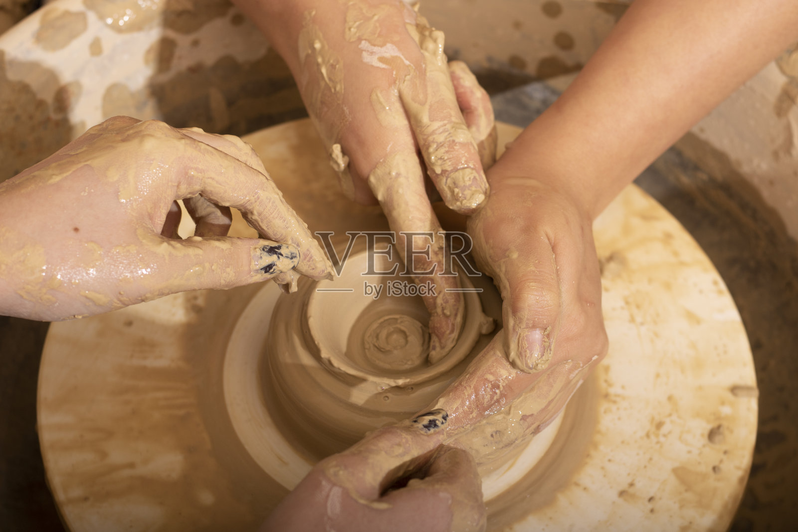 一个陶工的手，在圆圈上创造一个陶罐，俯视图照片摄影图片