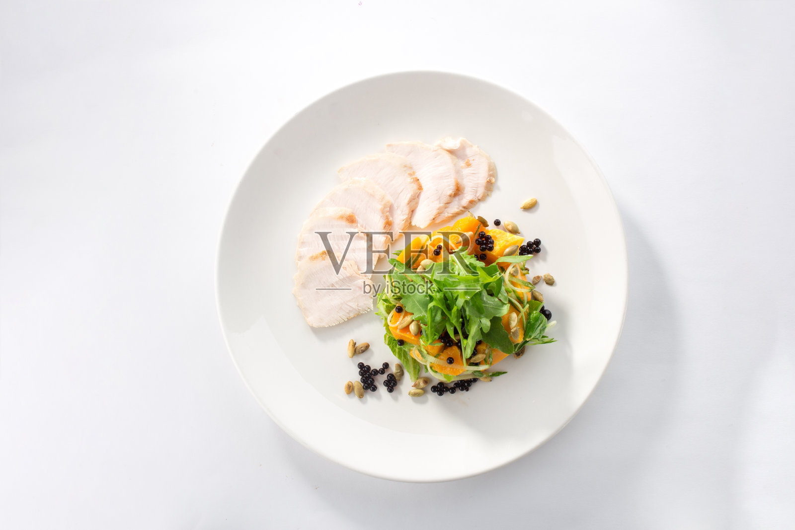 烤火鸡片与南瓜和绿色蔬菜在白色的盘子孤立的背景照片摄影图片