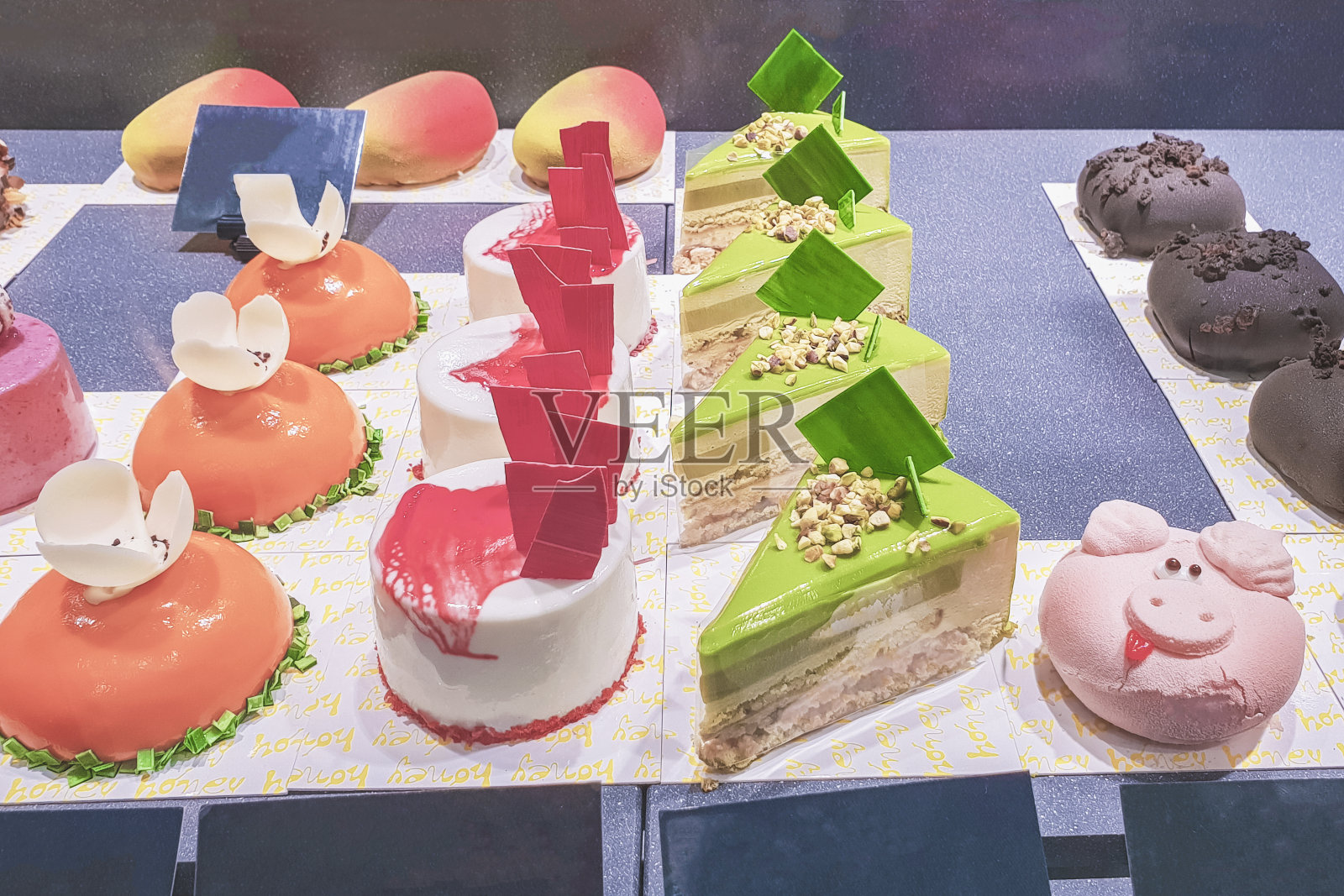 商店橱窗后面的蛋糕用不同的馅料和彩釉装饰，用水果和浆果装饰照片摄影图片