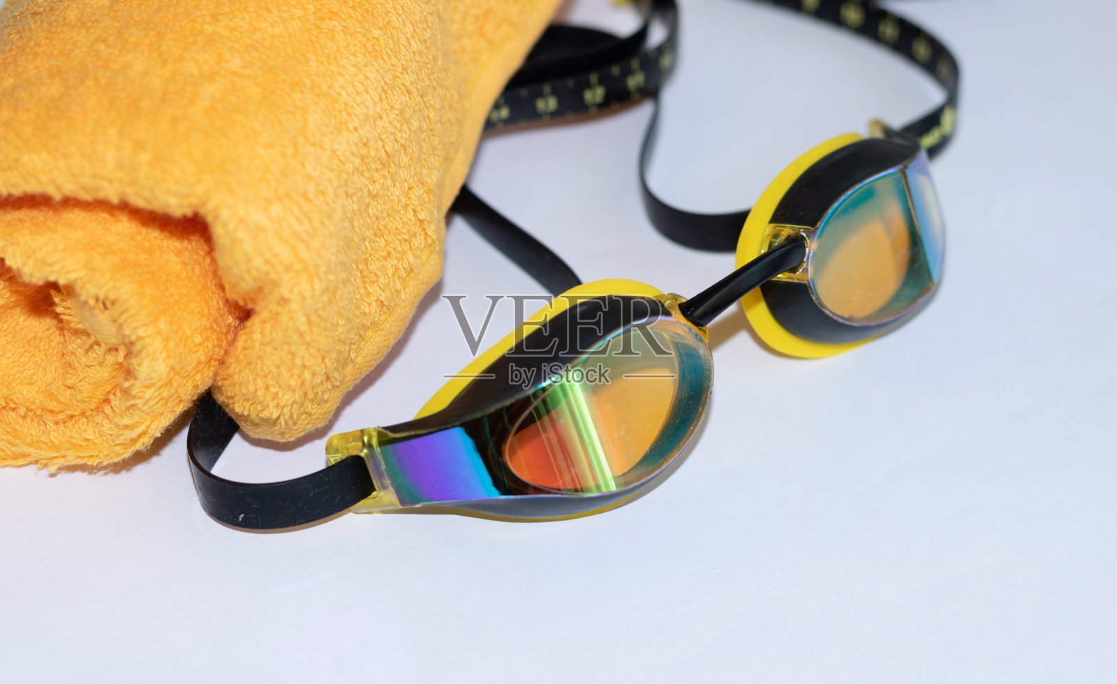 黄色毛巾，白色背景的泳镜照片摄影图片