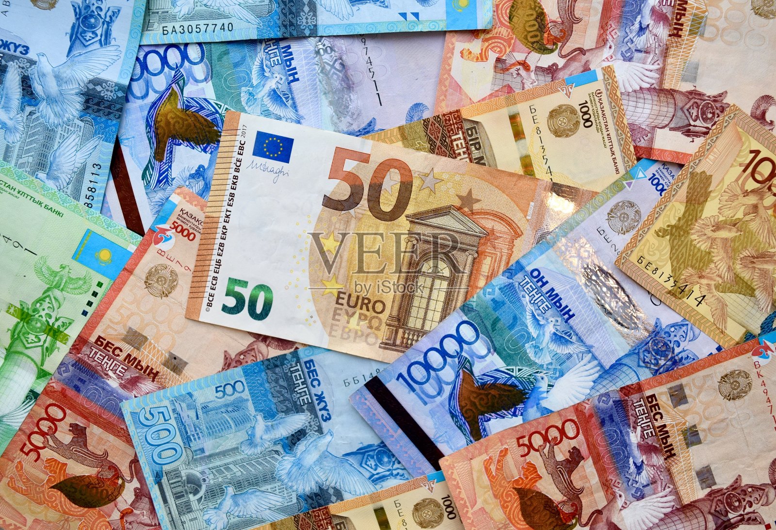 欧元钞票上面有哈萨克斯坦国家货币，俯视混合坚戈钞票。照片摄影图片