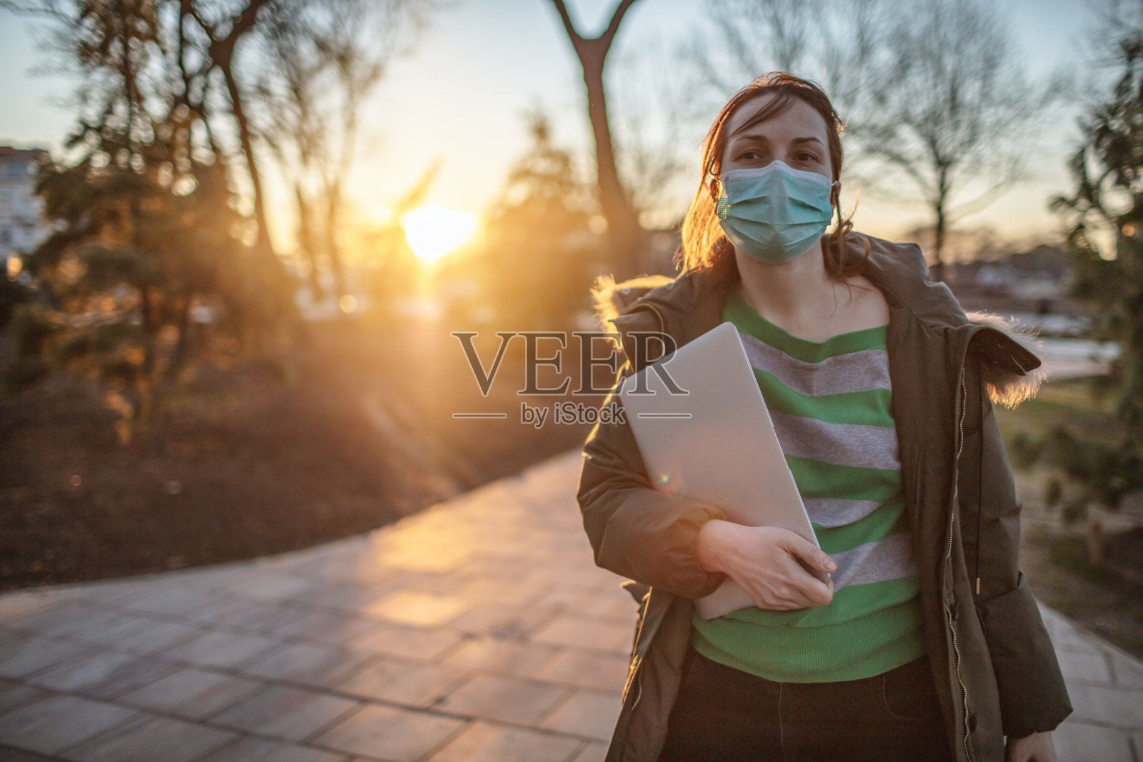 在户外戴着笔记本电脑和防护面罩的女人照片摄影图片