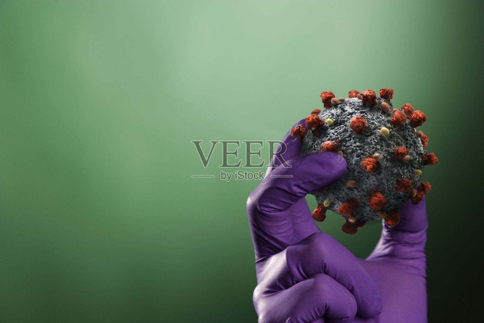 手戴防护手套，手持冠状病毒照片摄影图片