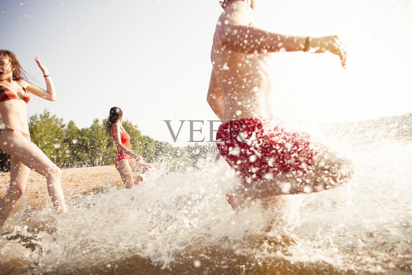 奔向水中的快乐朋友们照片摄影图片