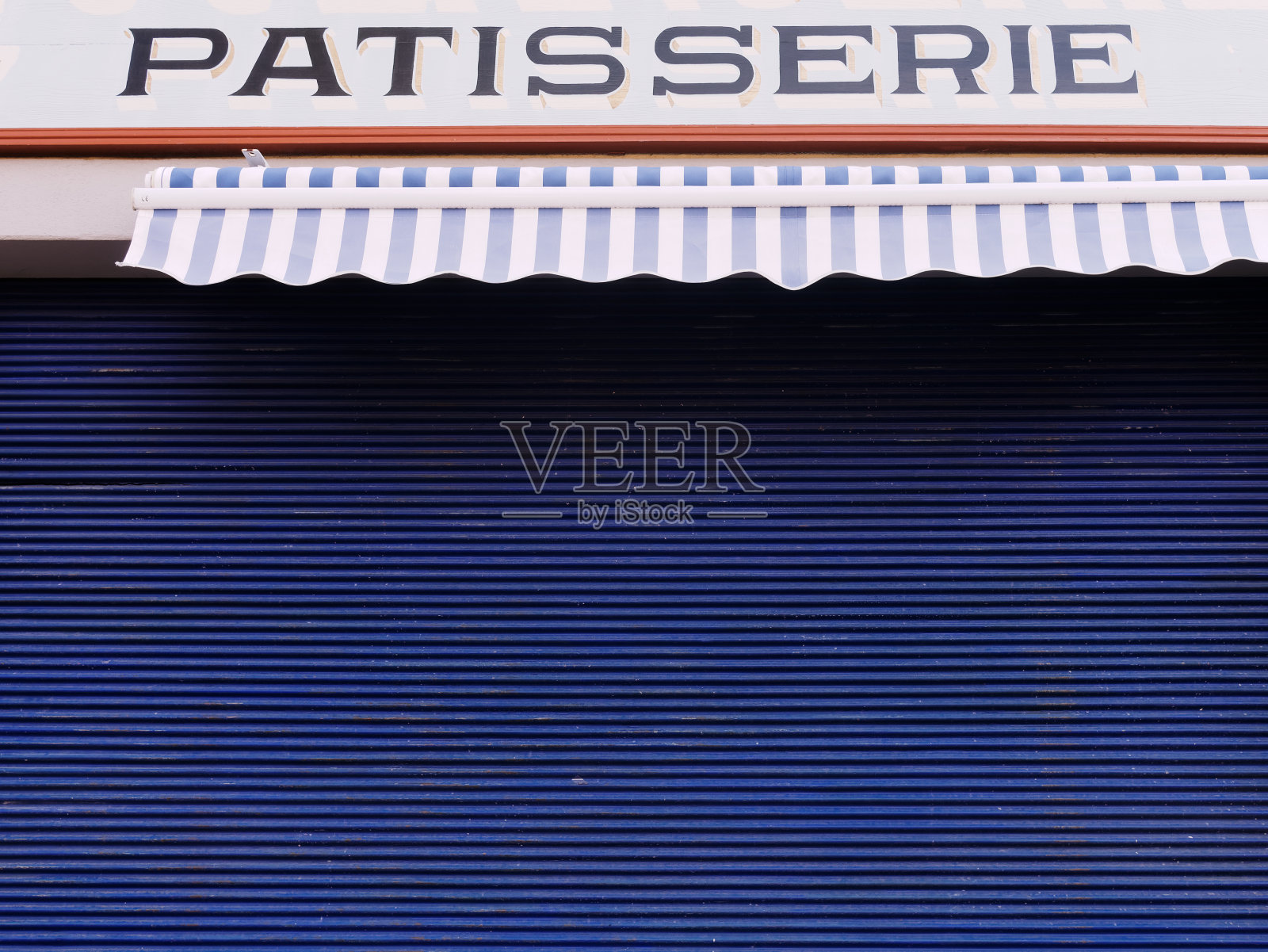 糕饼店与封闭的蓝色金属百叶窗背景与复制空间。照片摄影图片