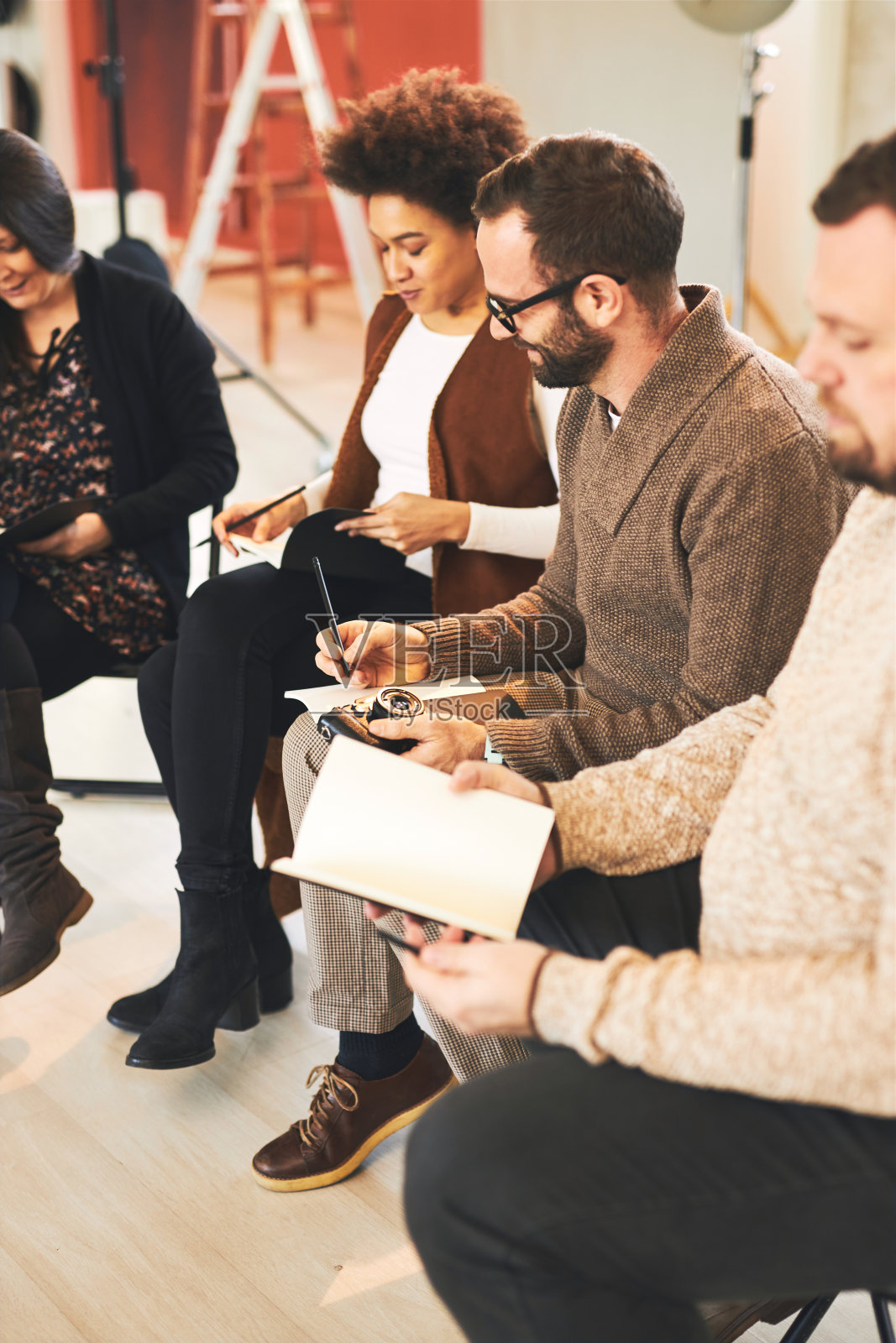 参加者在工作室就坐并记录摄影基础知识照片摄影图片