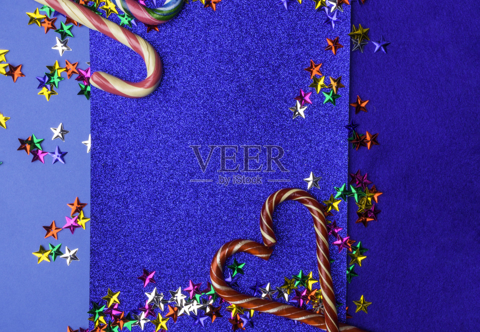 心形的条纹糖果拐杖上有五颜六色的星星照片摄影图片