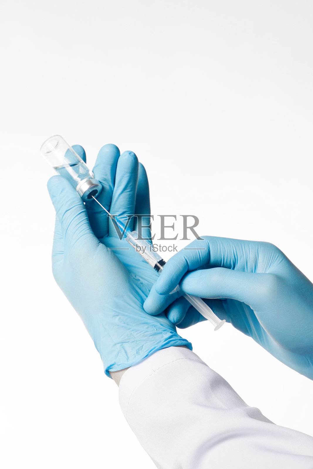 医生戴蓝色乳胶手套持安瓿瓶和注射器特写照片摄影图片