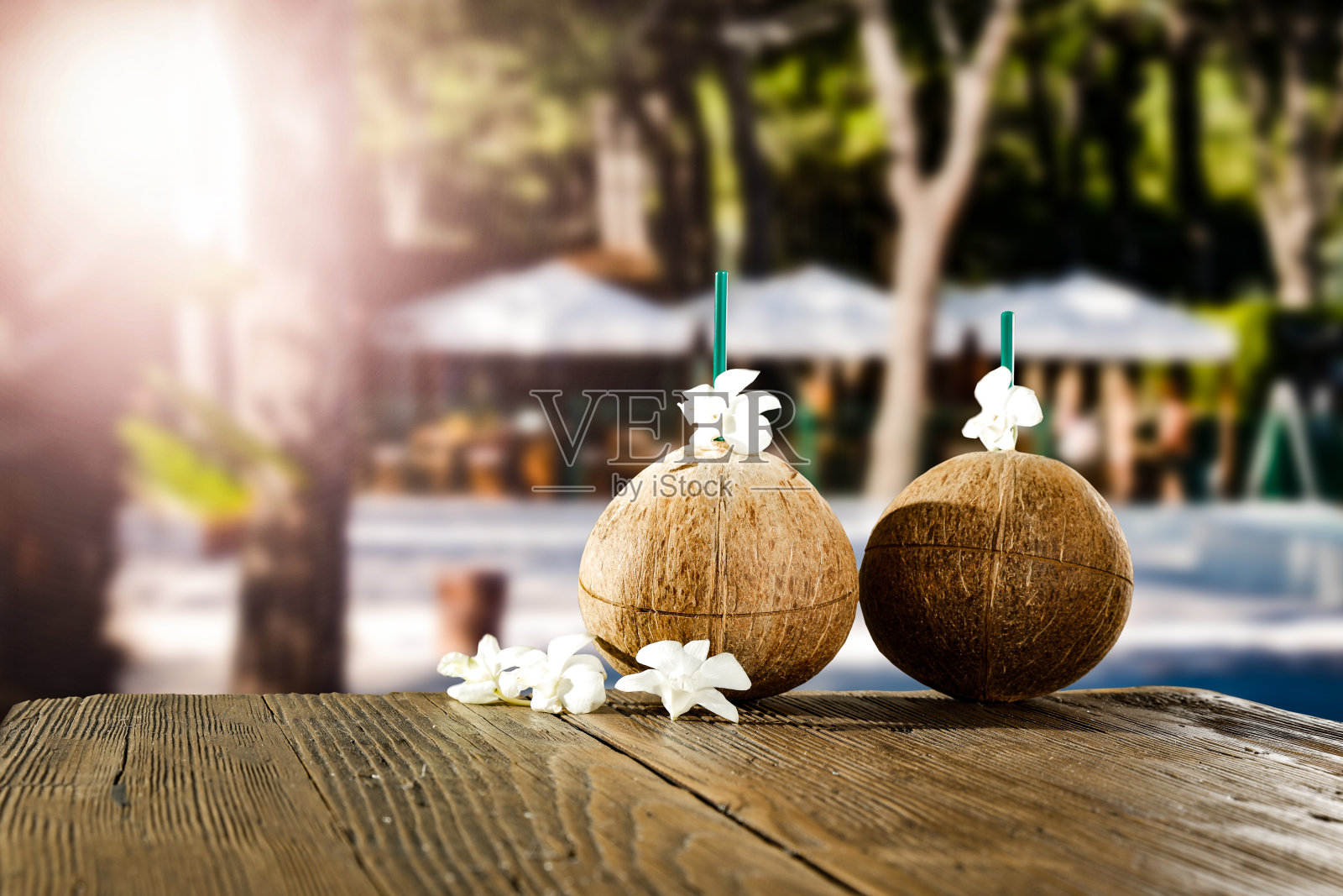 新鲜的椰子饮料和模糊的异国情调的树木和户外餐厅的背景。美丽阳光明媚的夏季时间背景。为广告产品复制空间。照片摄影图片