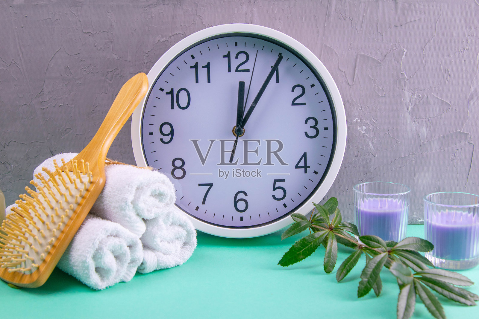 土耳其蓝背景下的三条毛巾、树枝、白色时钟和郁金香照片摄影图片