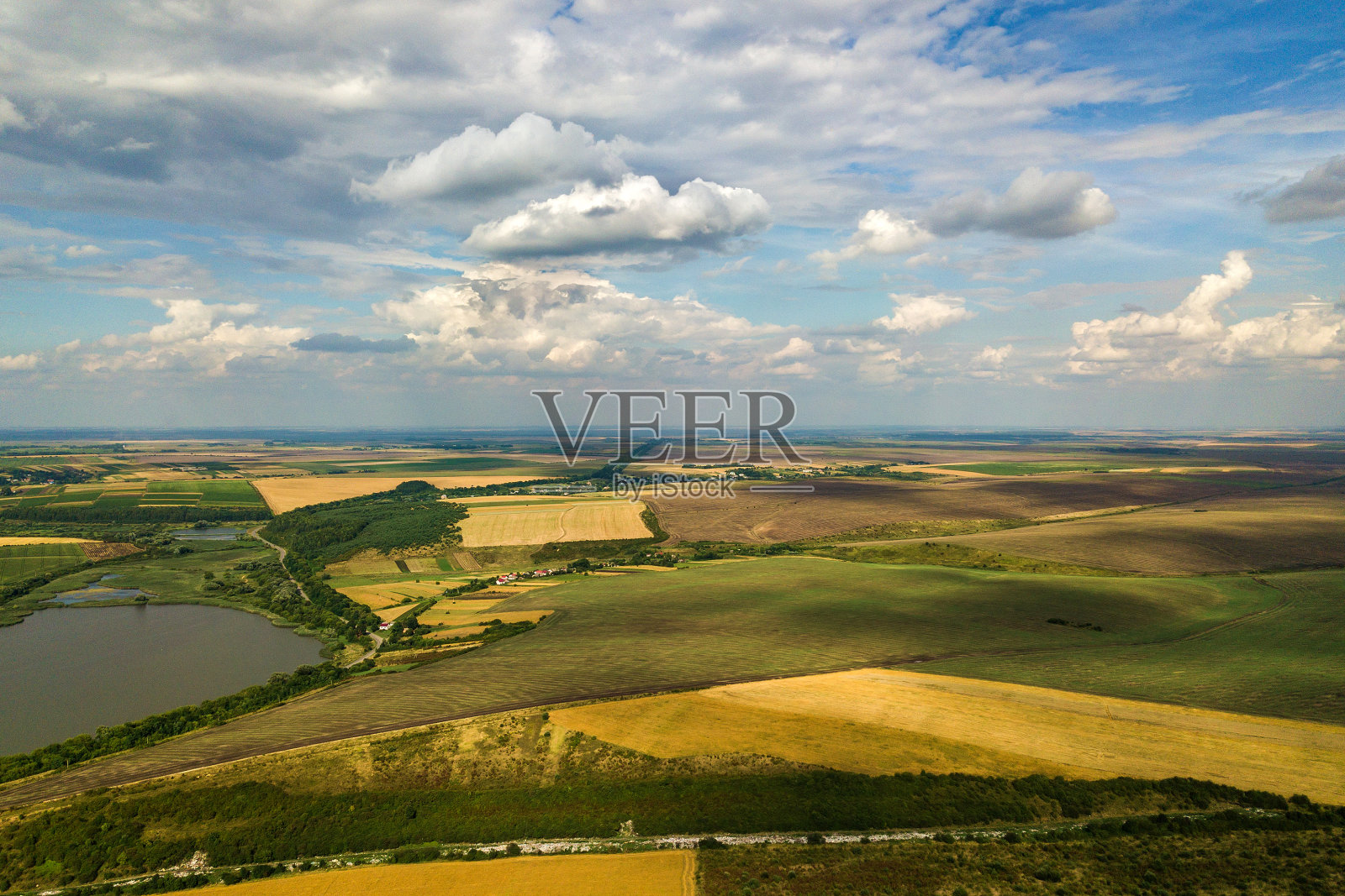 空中的乡村景观，点缀着黄色的农田和蓝天白云。照片摄影图片