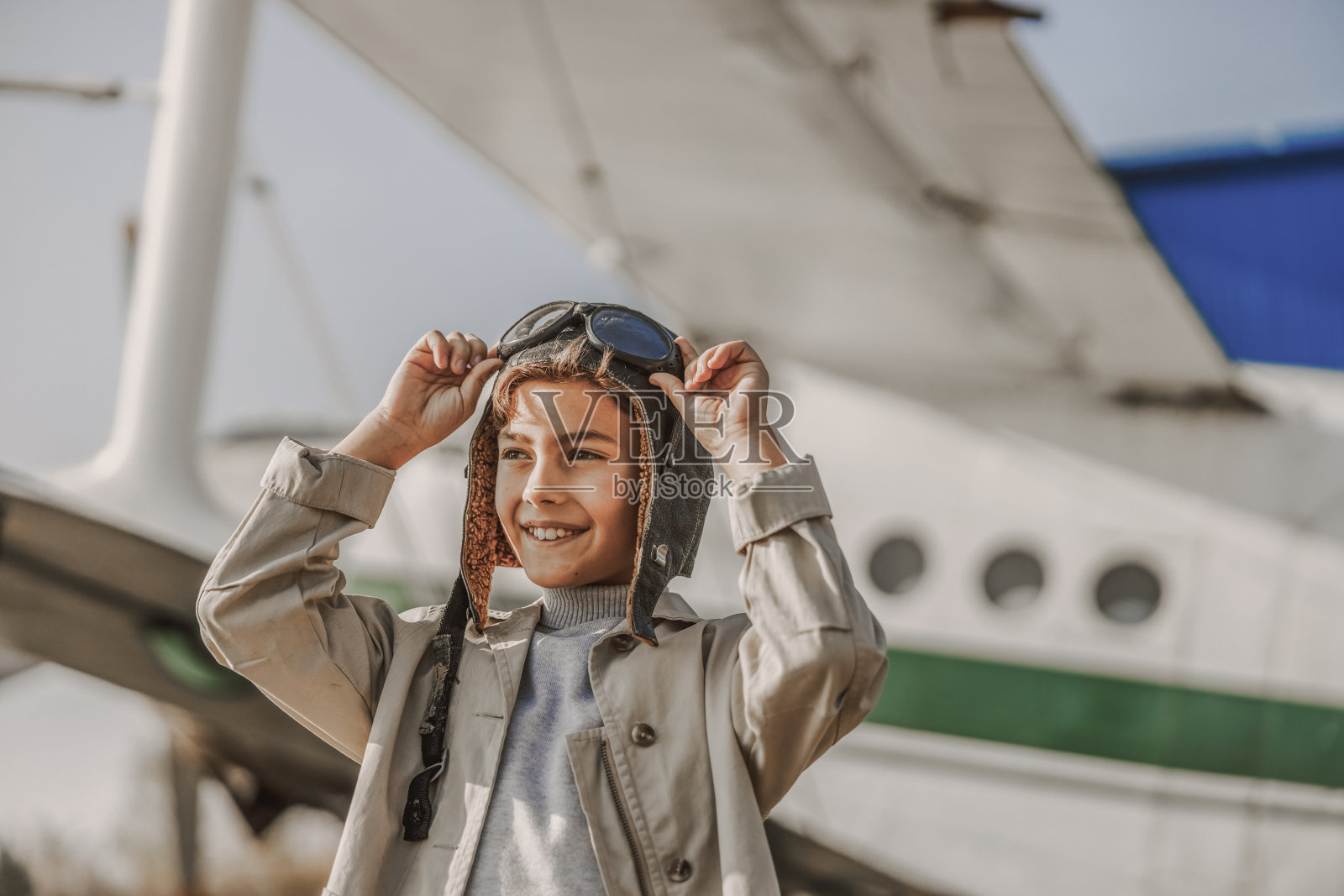 快乐的小男孩拿着飞行员眼镜照片摄影图片