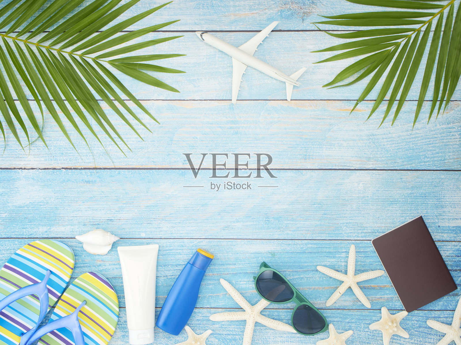 海滩配件热带棕榈叶，护照，太阳镜浅蓝色背景。旅行的概念。照片摄影图片