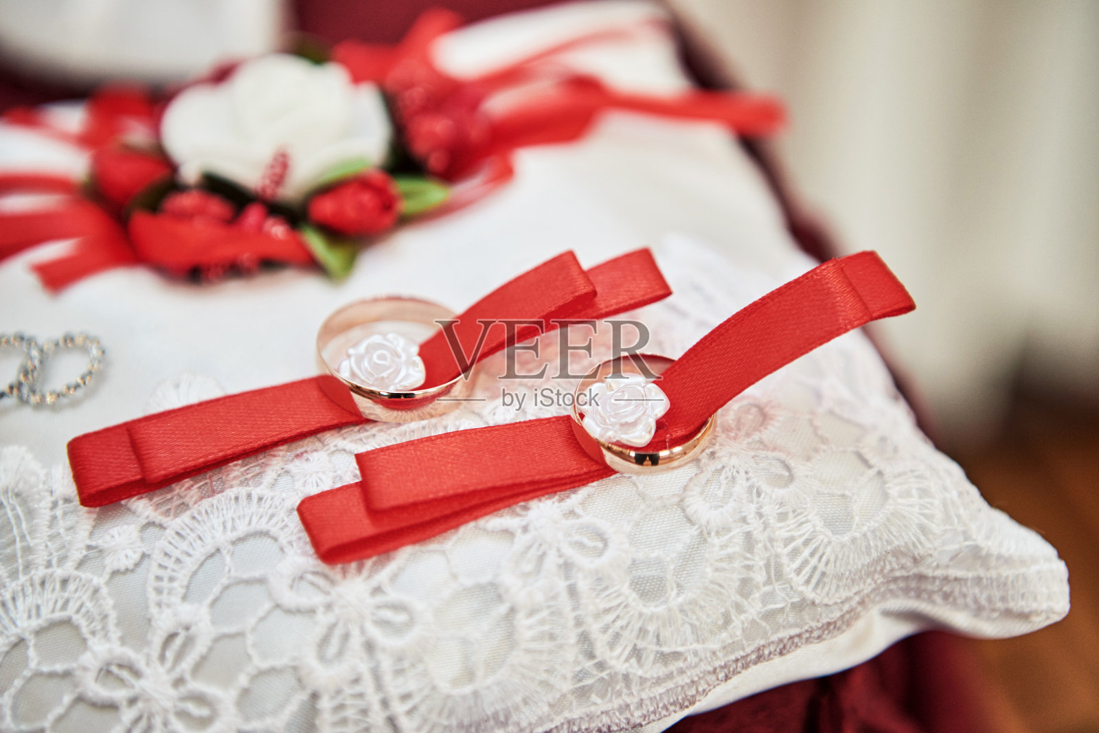 两个金结婚戒指放在一个小缎子枕头上照片摄影图片