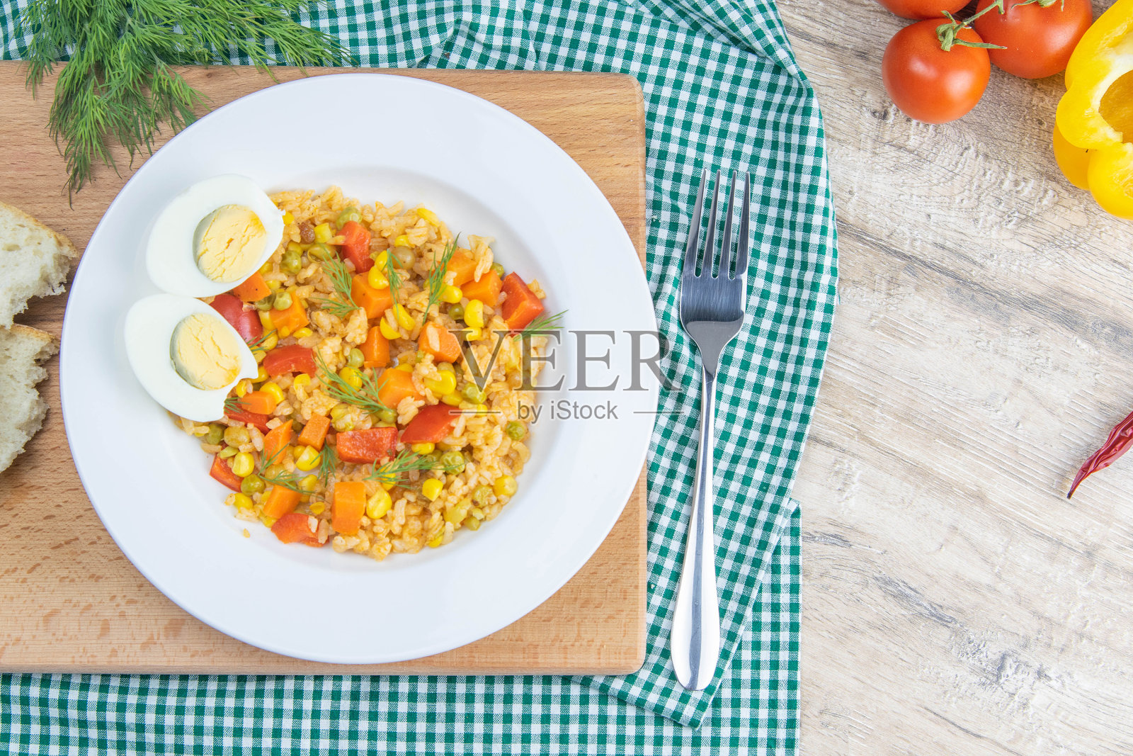 健康食品。白米饭，鳄梨，樱桃番茄，绿豌豆和榛子。在木制的背景上。上面的观点照片摄影图片