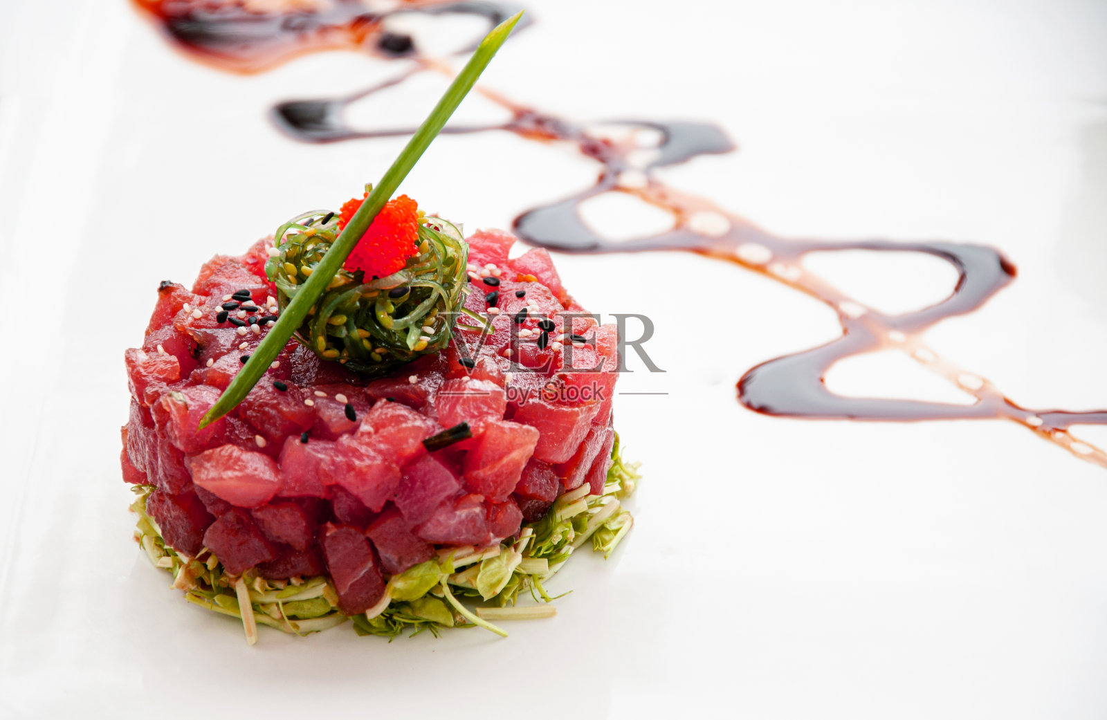 新鲜金枪鱼，鞑靼，芝麻，海藻，绿色沙拉和香醋还原酱照片摄影图片