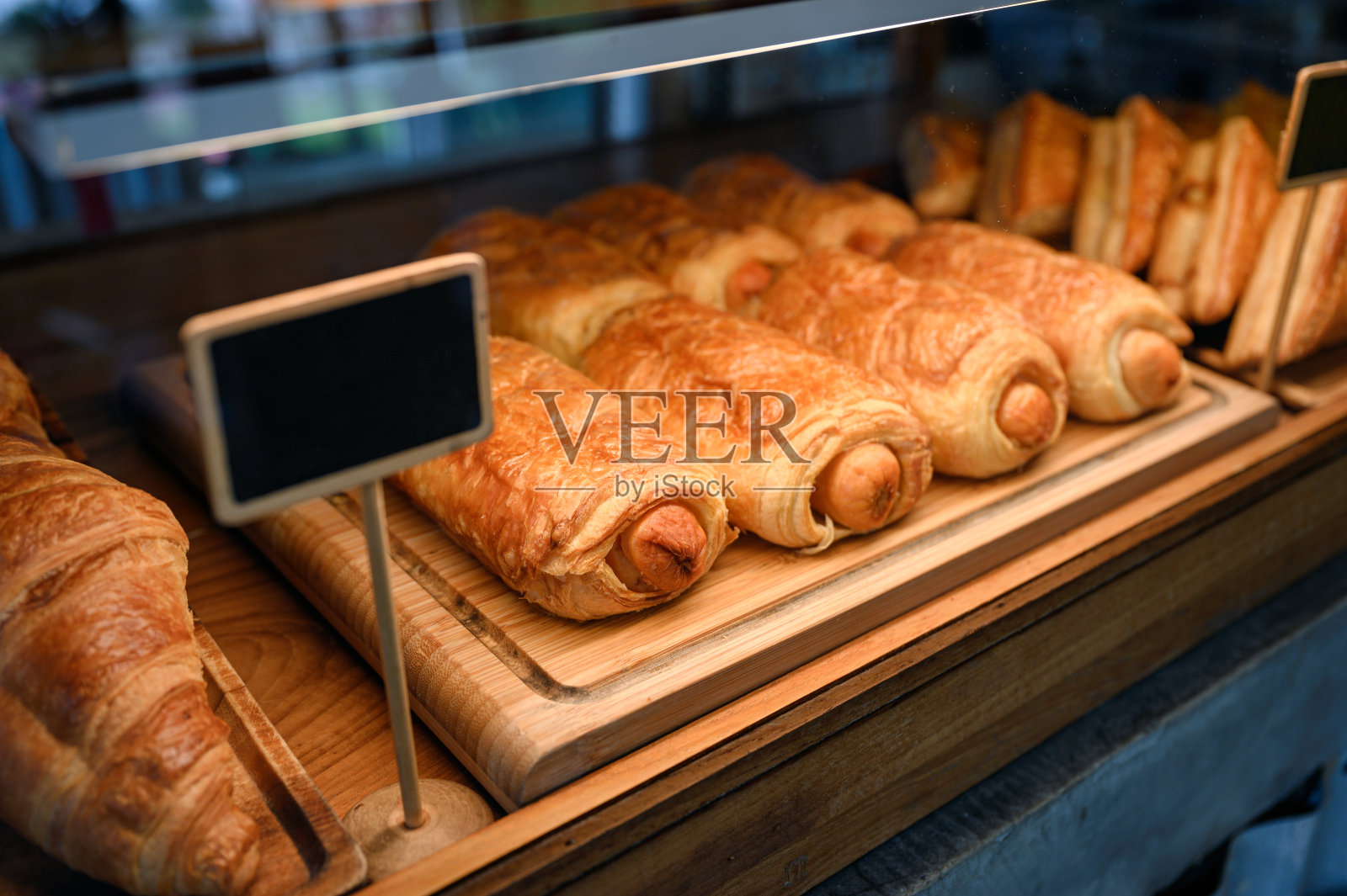 烤香肠卷面包放在橱柜的木托盘上照片摄影图片