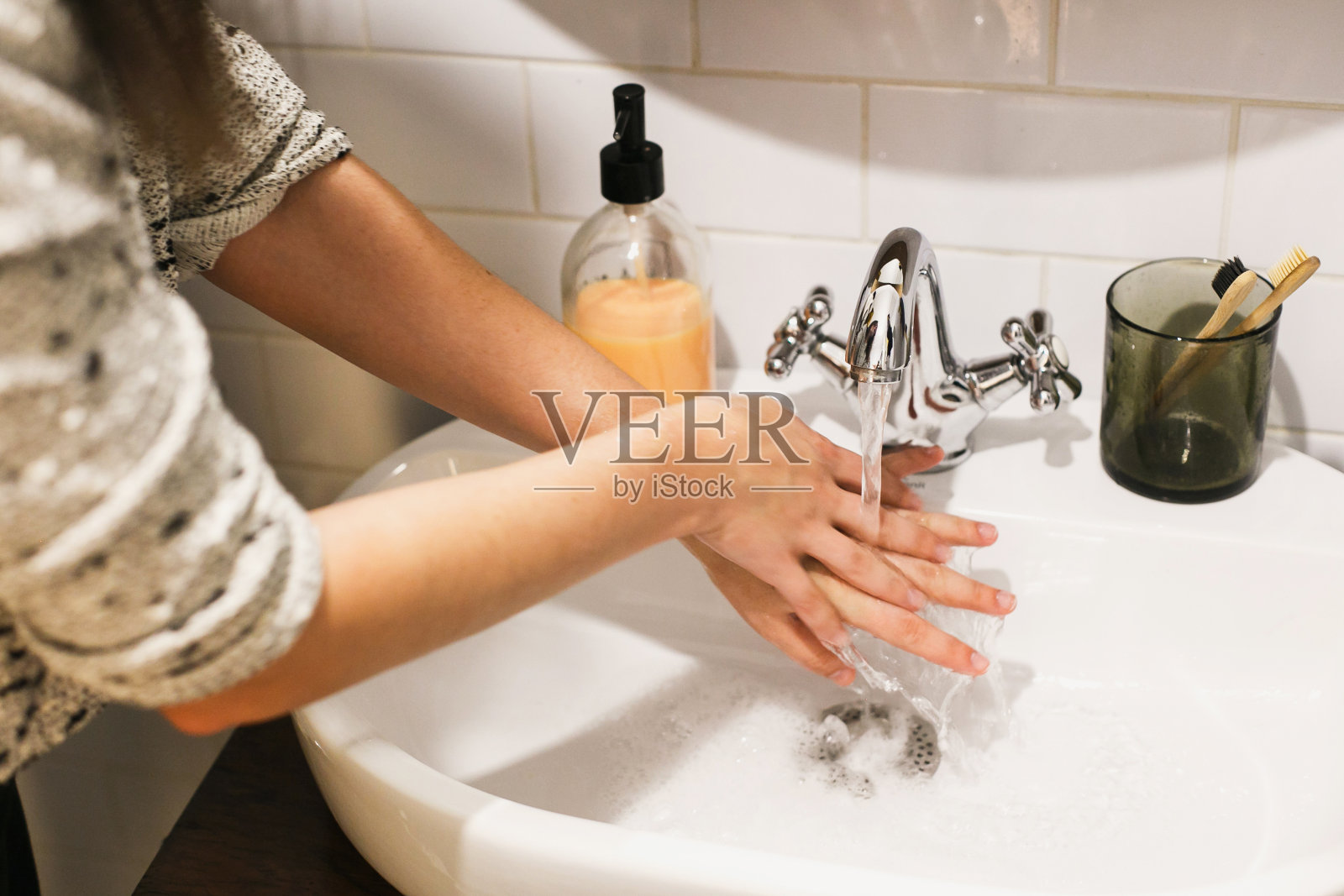 洗手。在浴室内使用抗菌肥皂在流动的水中洗手。预防冠状病毒疫情。预防流感。照片摄影图片