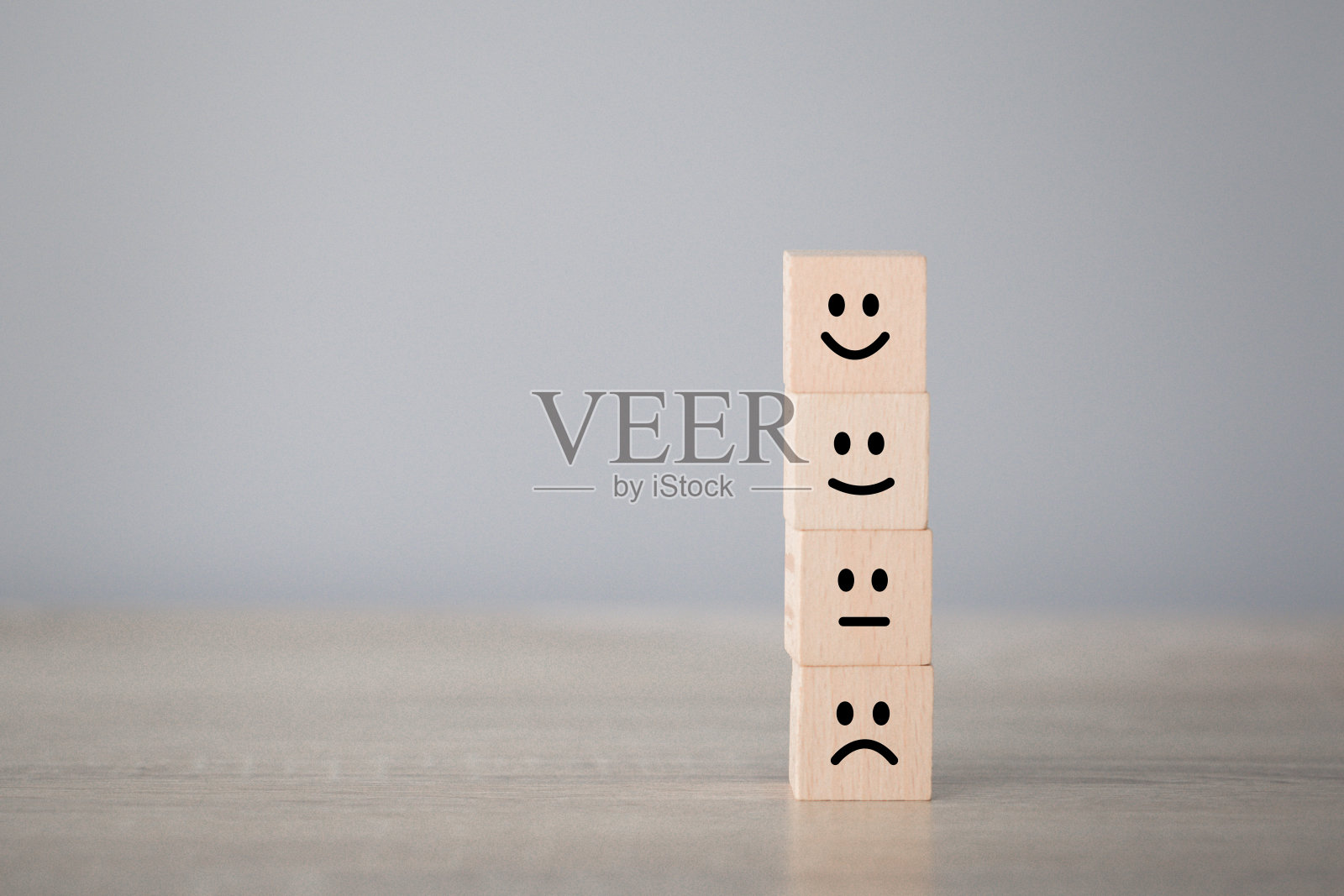 客户按笑脸表情在木方上，服务评级，满意度概念。照片摄影图片