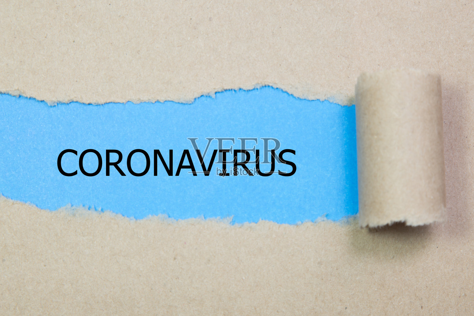 撕破的纸后面出现了冠状病毒这个词照片摄影图片