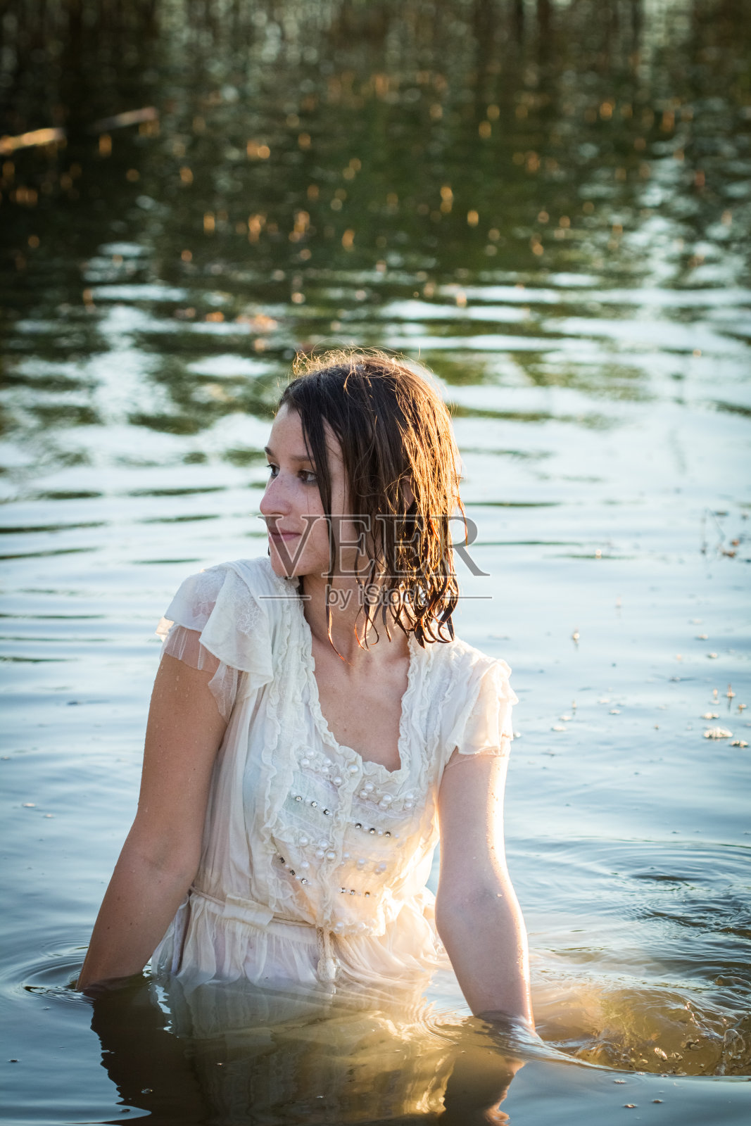 穿着衣服的女人在湖里享受照片摄影图片