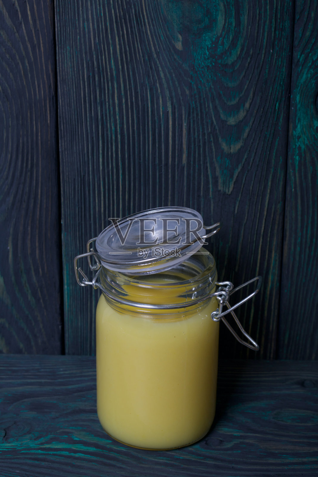玻璃罐里的柠檬汁。以拉丝板为背景。照片摄影图片