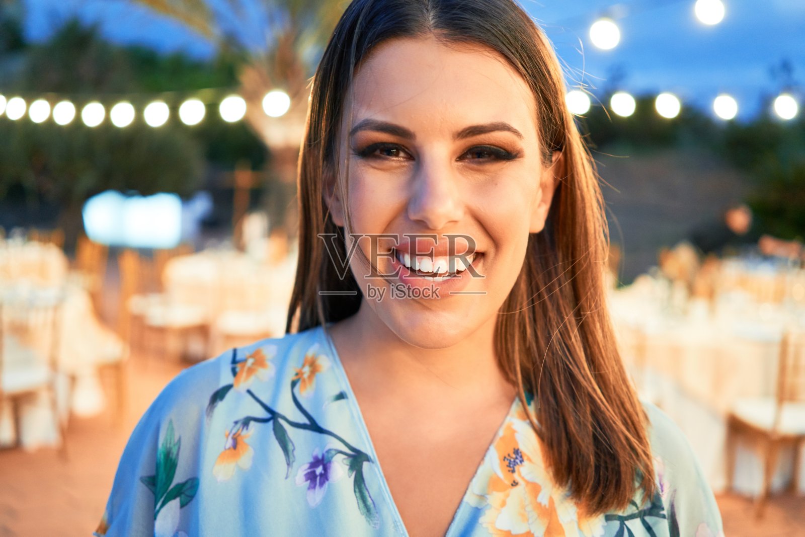 年轻漂亮的优雅女子身穿参加婚礼的礼服，在宴会上笑容满面，心情愉快照片摄影图片