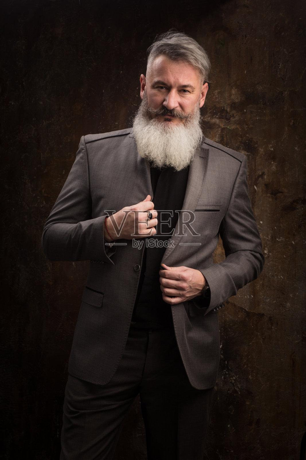 深色背景下身着正装的中年络腮胡男人肖像（选择性聚焦）照片摄影图片