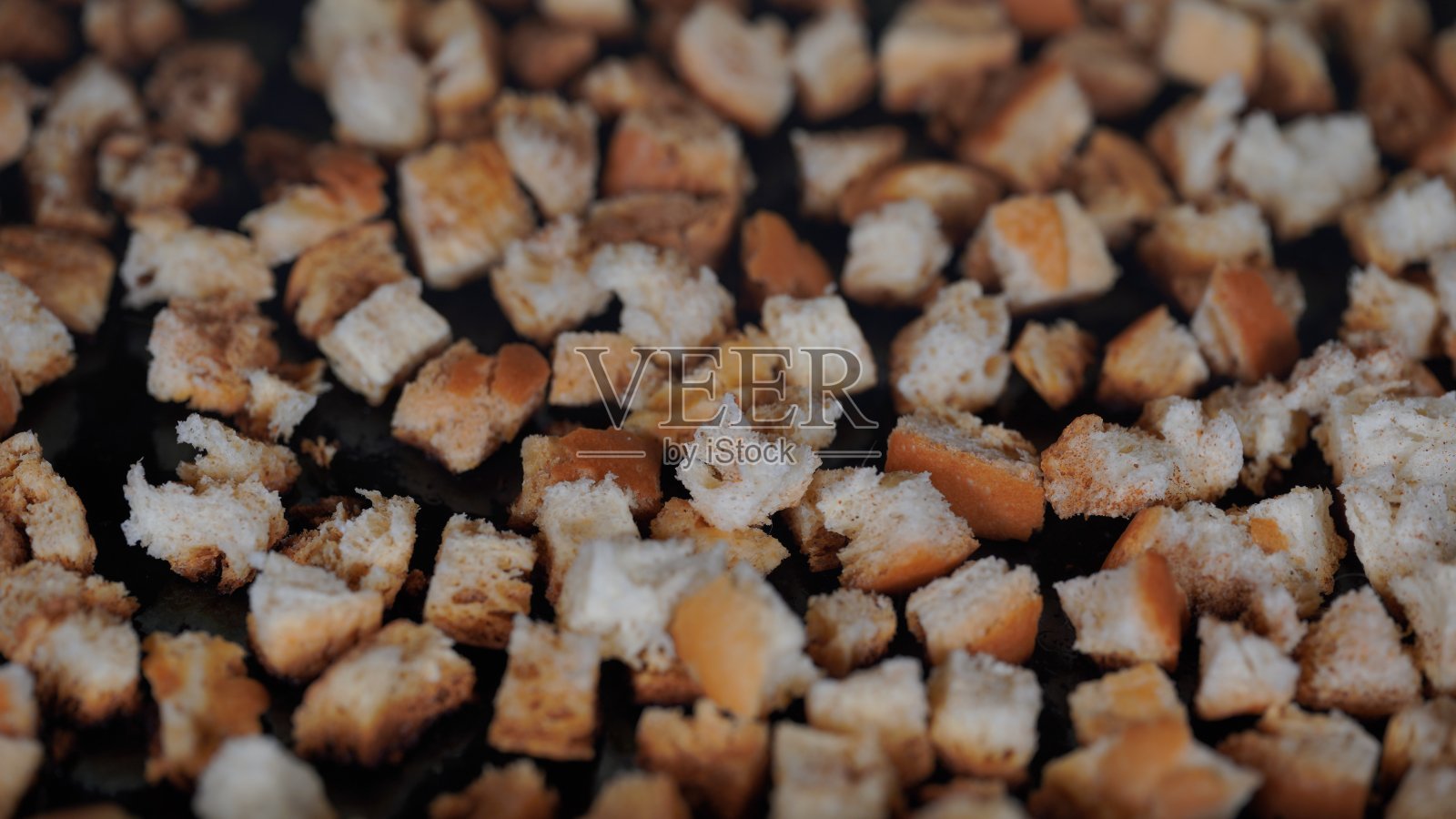 用自制白面包制作的饼干或干面包在烤箱里烘烤，特写镜头。烹饪油炸面包丁。干黑麦面包片的质地照片摄影图片