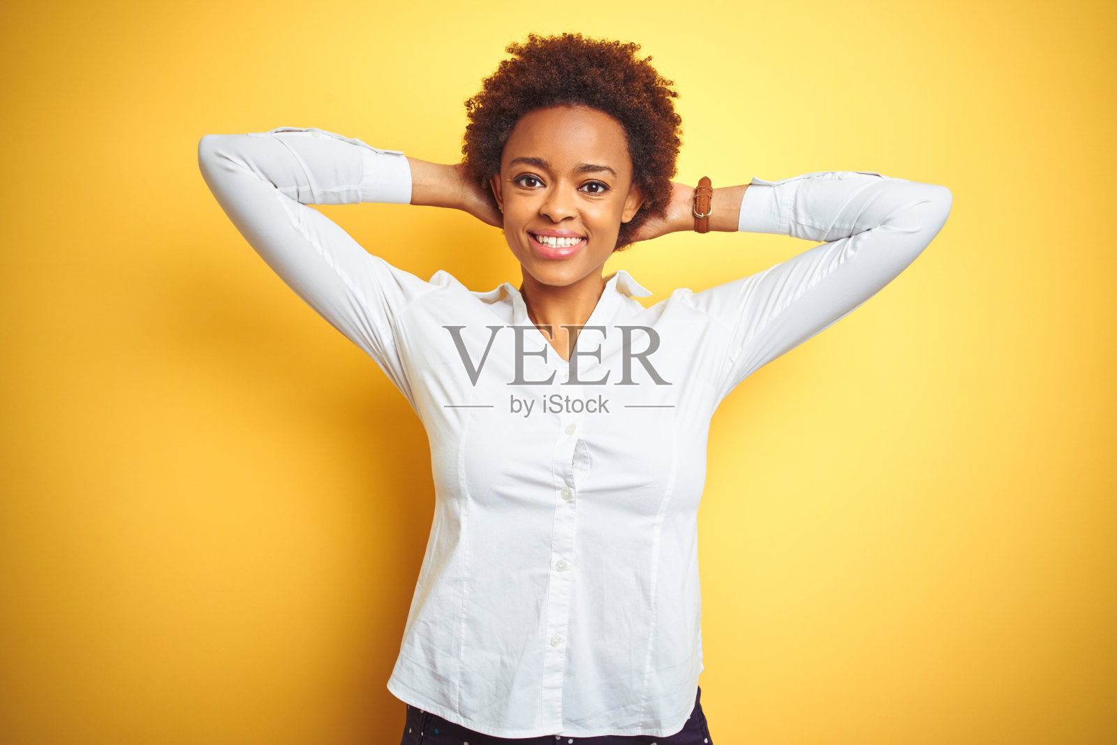 非洲裔美国女商人在孤立的黄色背景下放松和伸展，手臂和双手后头颈微笑幸福照片摄影图片